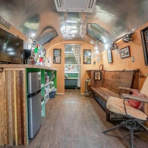 Relax and unwind with a comfy armchair and eclectic bench seating in the Airstream