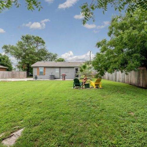 Large fenced pet friendly back yard with picnic table, seating and chiminea area