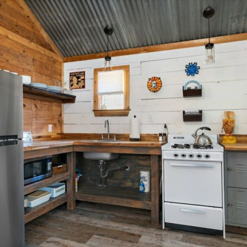 Cottage Kitchen with full size refrigerator, gas stove, coffee pot and microwave.